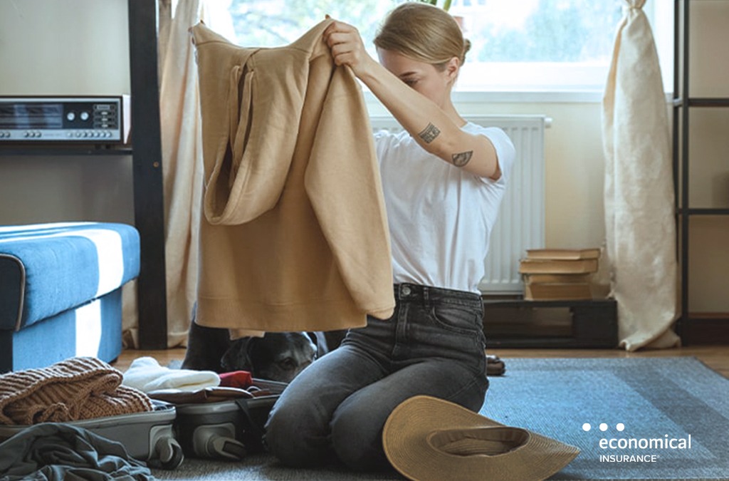 Woman looks at sweater in her home deciding what to insure