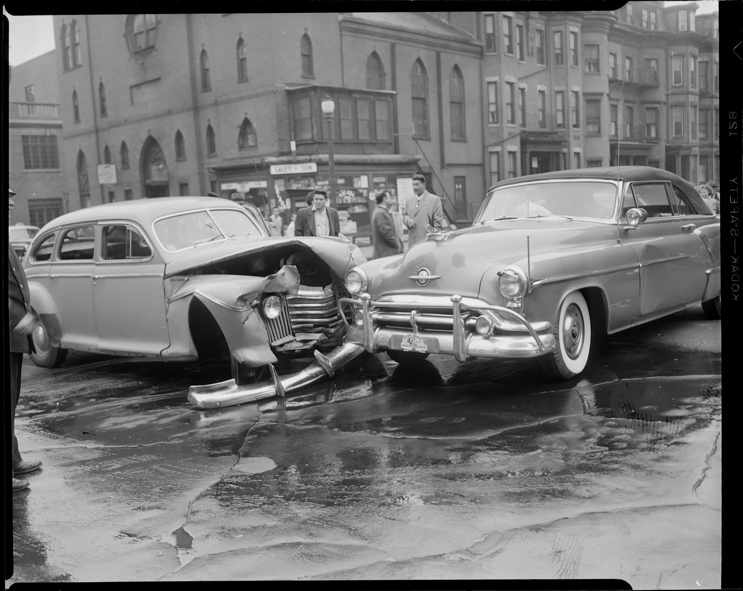 Two old cars collide in a black and white photo