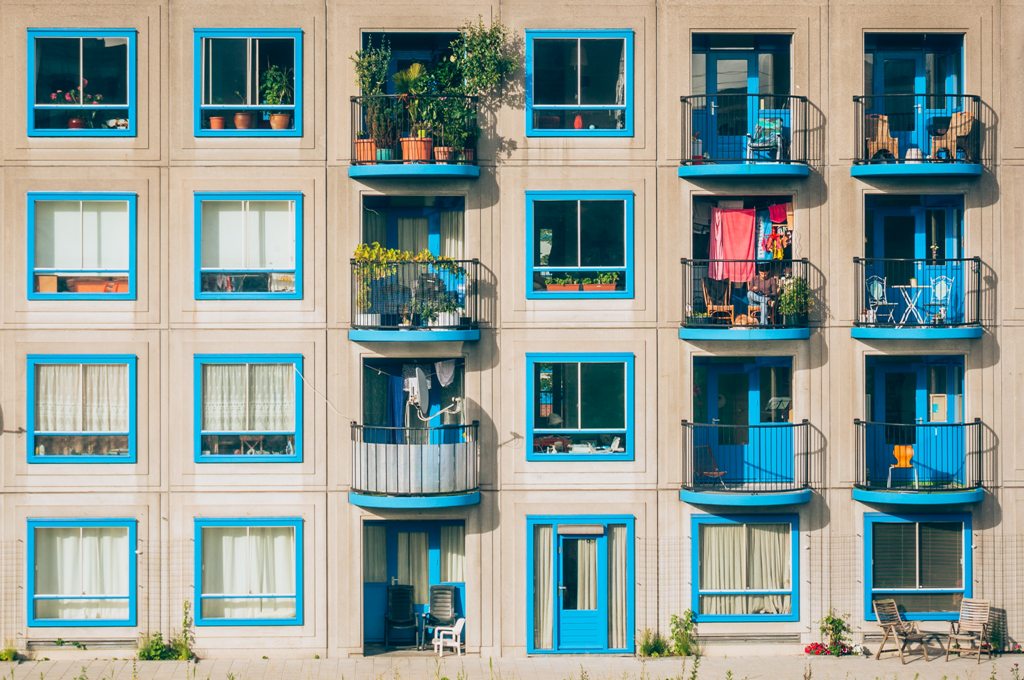 Charming blue doors and window trim of 4-storey apartment building