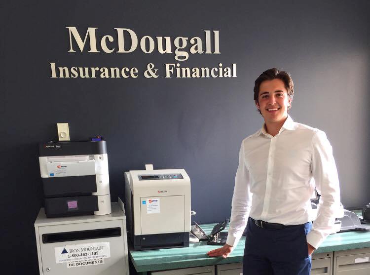 ryan mckenna stands next to a printer in the McDougall office