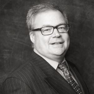 Scott Terhaar in black and white photo, wearing suit and tie