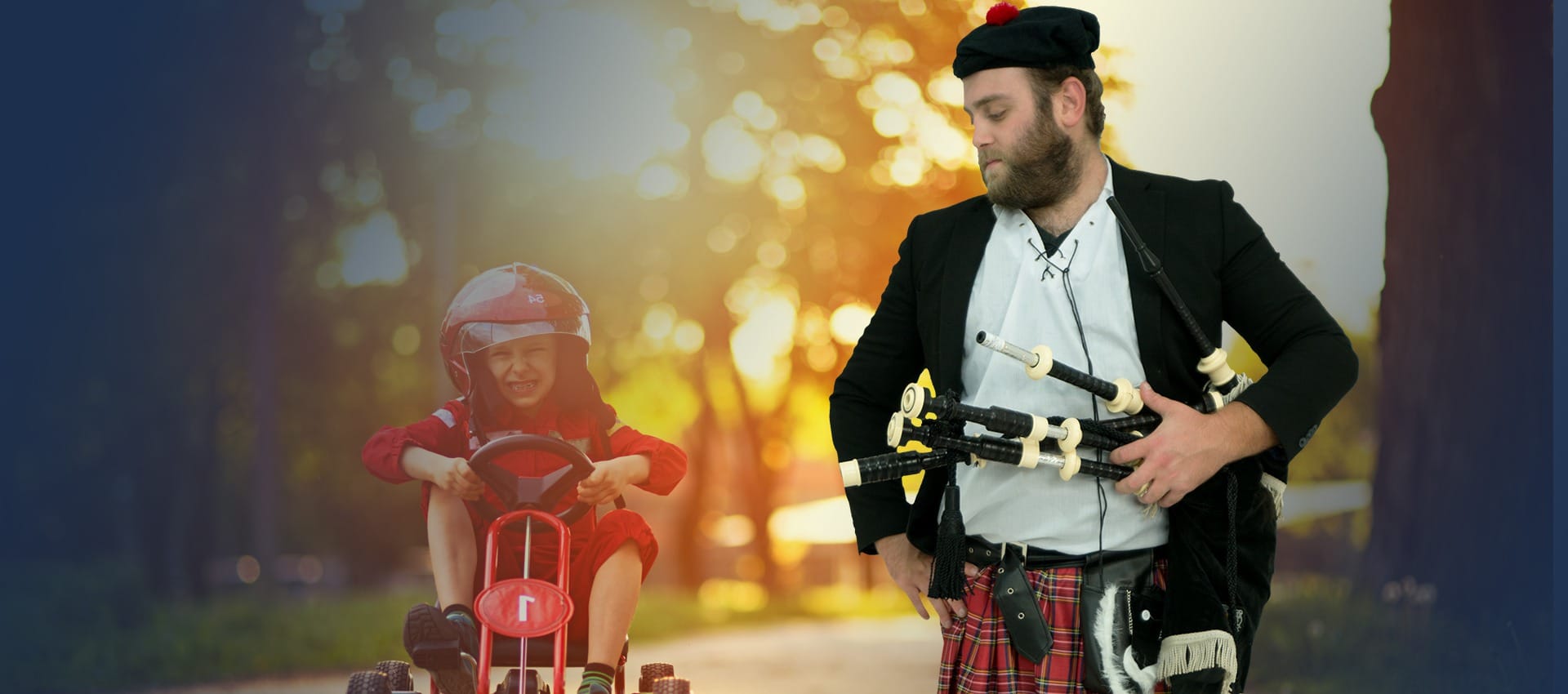 Kid on bike wearing helmet, man in kilt with bagpipes standing beside kid