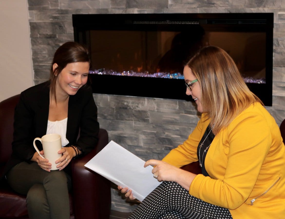 Two insurance professionals going over some paperwork and smiling