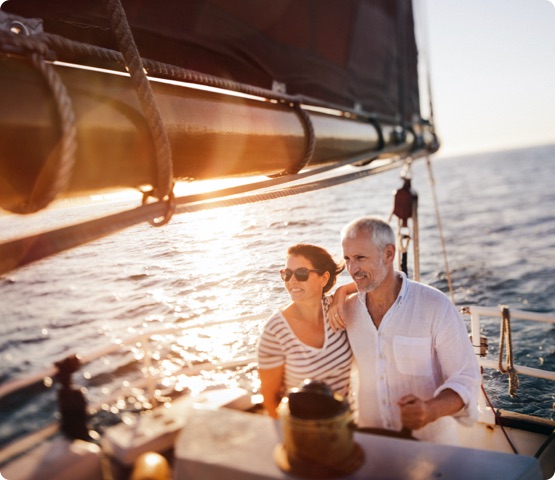 Dreamy shot of couple enjoying the fresh ocean breeze on their leasure cruise on their yacht