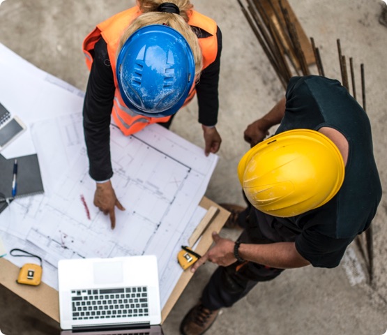 Two architects examining the blueprints on construction site