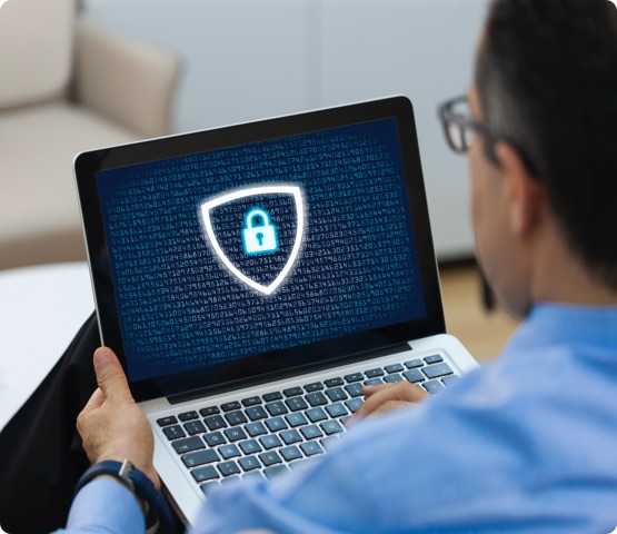 Person looking at their laptop screen of a cybersecurity symbol