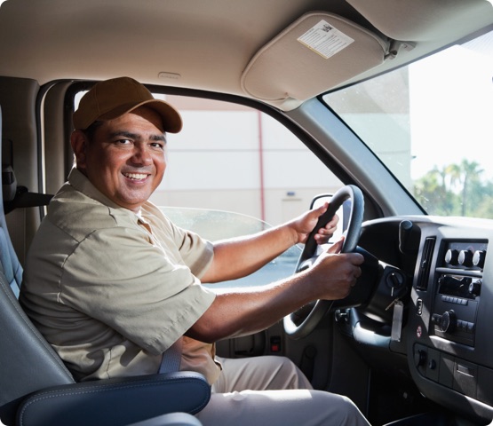 Person wearing uniform driving commercial van.