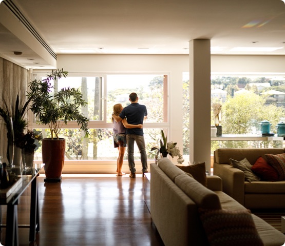 Couple admiring the view from the living room of their house.