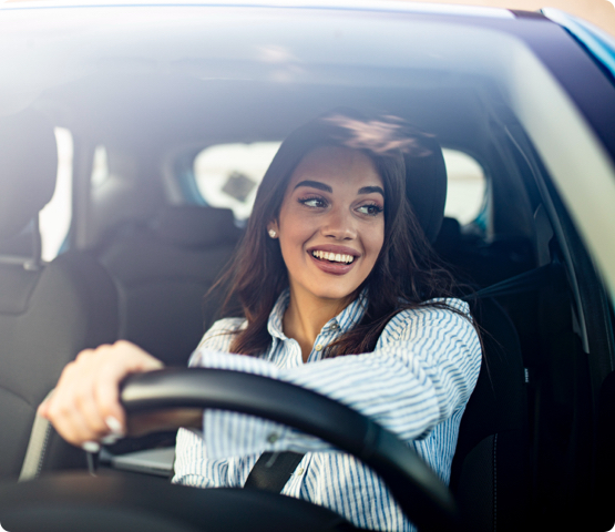 Person smiles while driving because they found an awesome broker for car insurance