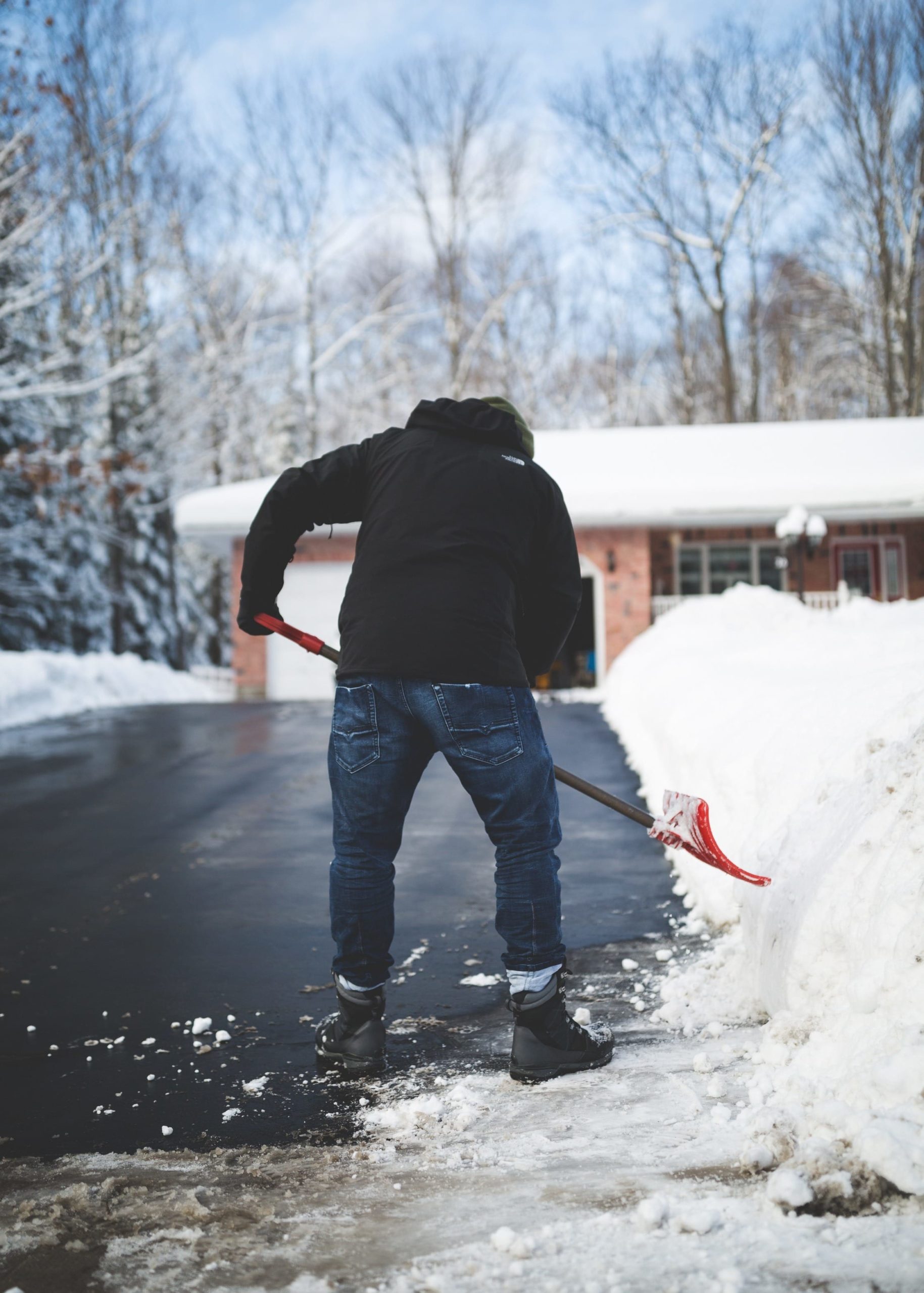 a man shovelling his driveway