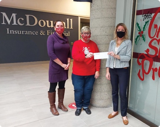 3 people wearing masks holding donation cheque in McDougall office