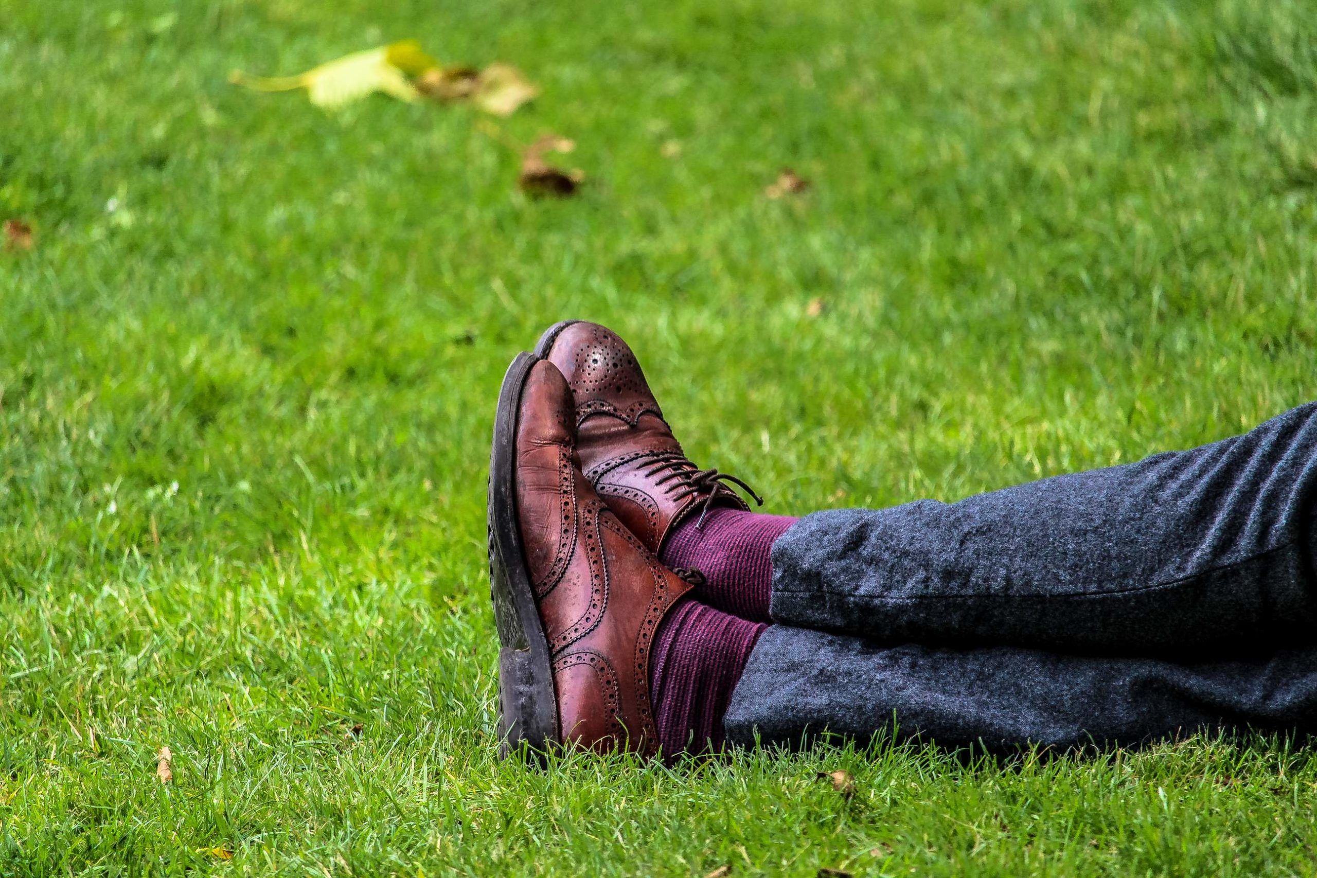 person's legs lying on the green grass
