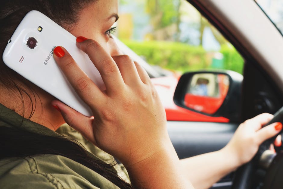 person talking on a cell phone while driving