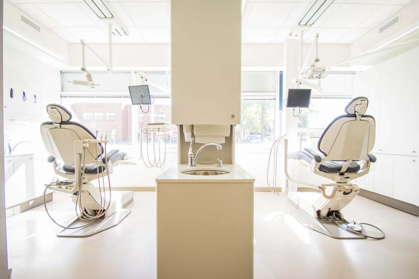 2 empty white dentist chairs in a clean environment