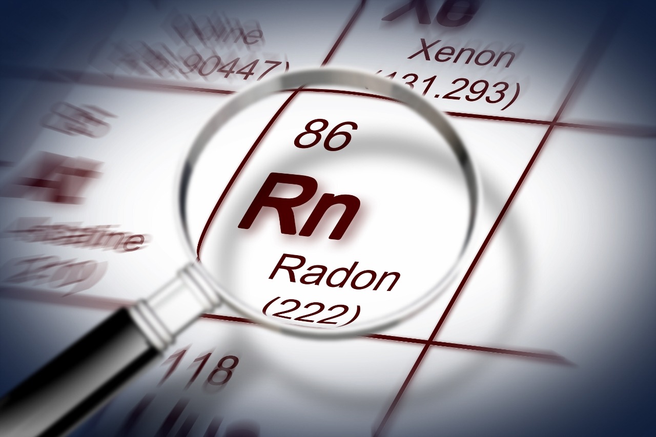 Magnifying glass shows close-up of radon as RN (222) on paper