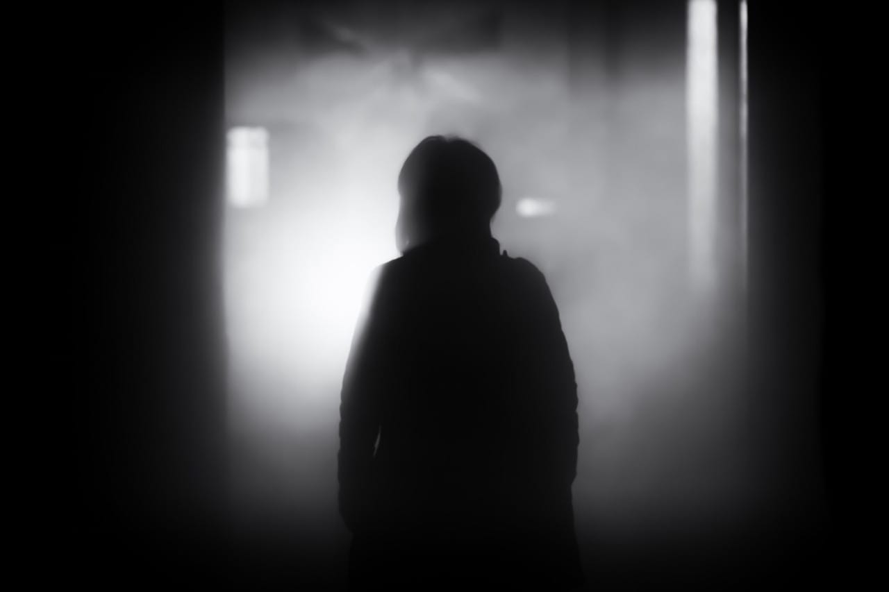 person standing looking at blurred scene and light