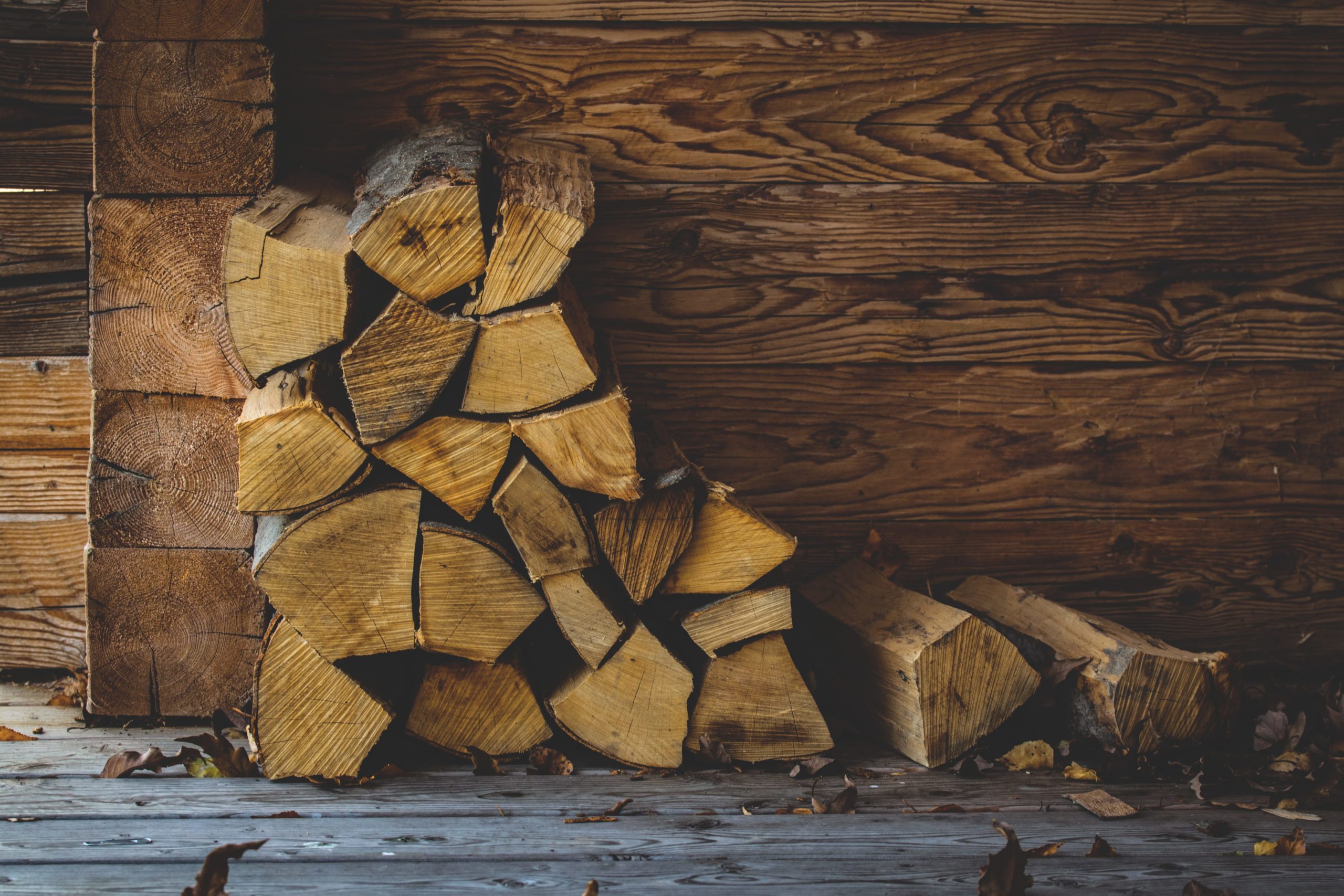 split firewood stacked up against a wall